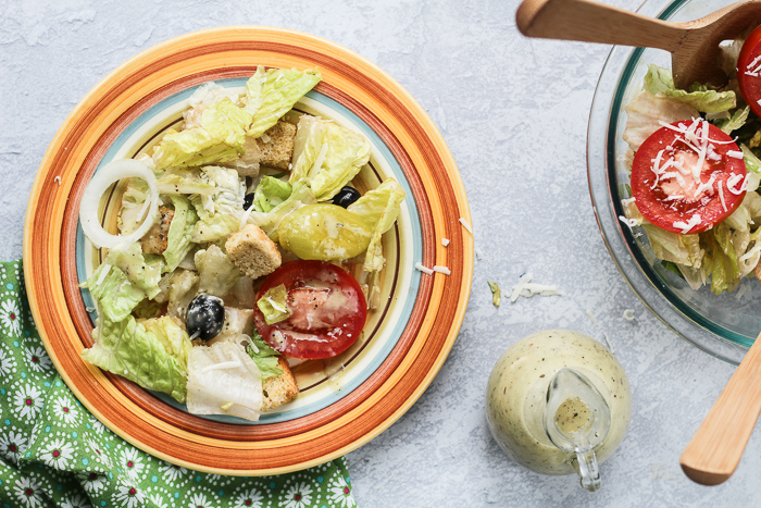 aerial view of salad in a bowl with dressing on the side