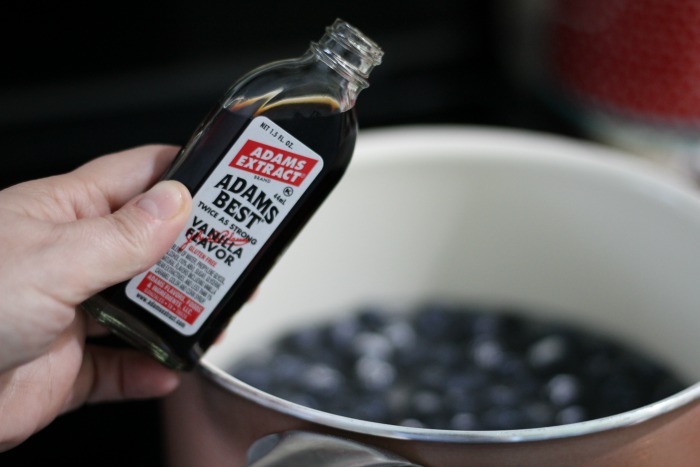 Vanilla extract adding to blueberry sauce