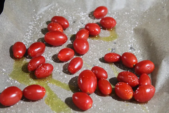 cherry tomatoes being prepared to go in the oven