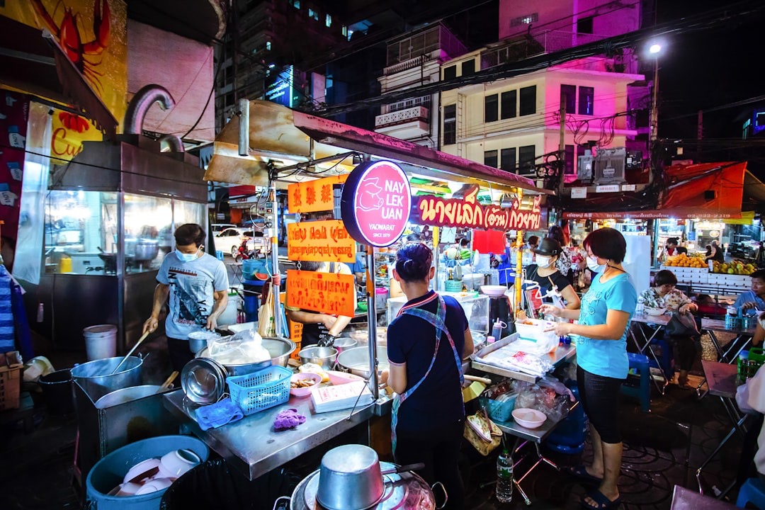 Family eating street food at a night market in Bangkok, Thailand